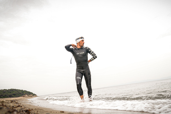Swimmer in a wetsuit preparing for a wild swim in the UK